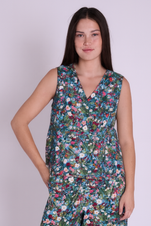 Woman wearing a floral jumpsuit on a plain background