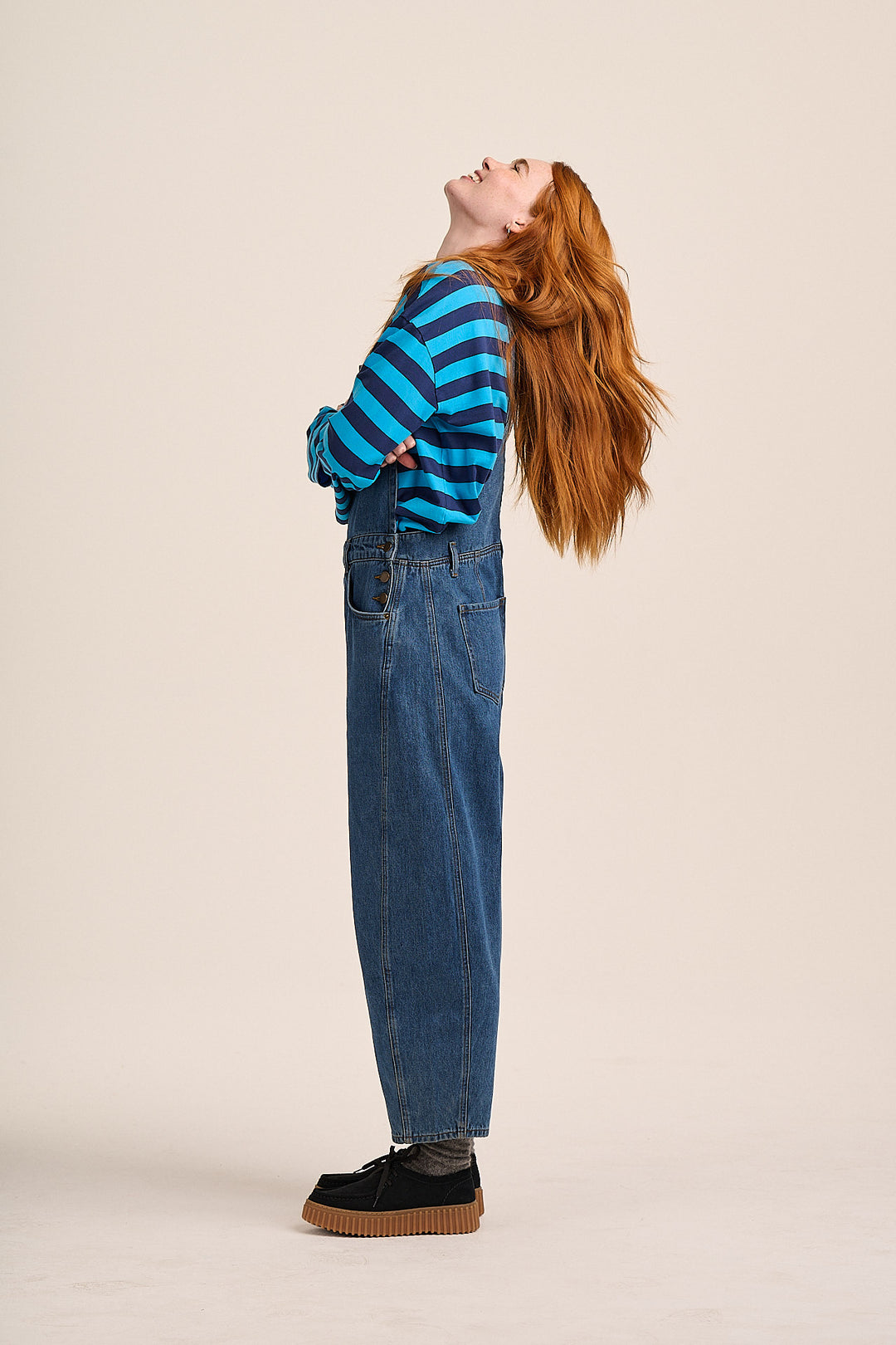 Close-up of denim dungarees with Strong Girls Club branded buttons