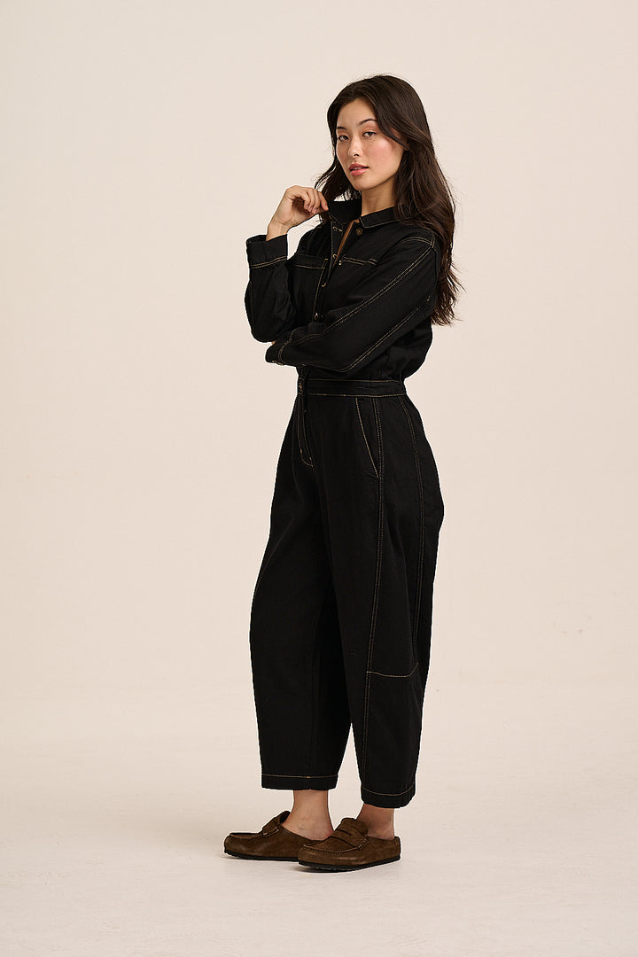 Side view of the Gracie black denim jumpsuit in soft cotton denim, showing the contrast stitching and cropped leg