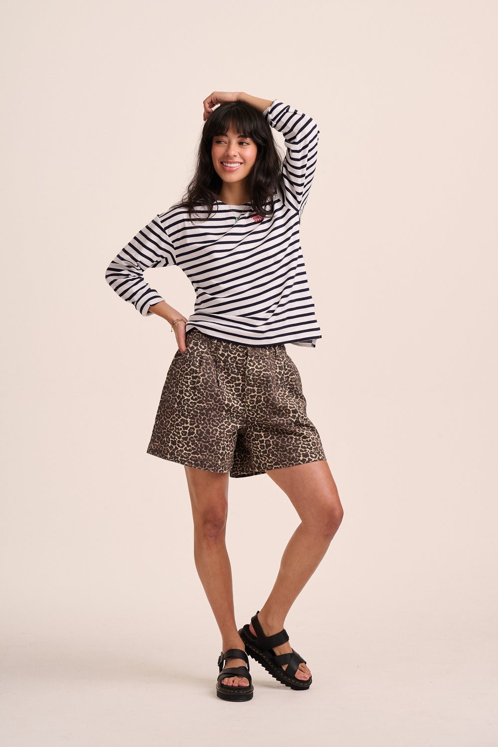 Model wearing leopard print pleated shorts with a navy breton striped top and black sandals