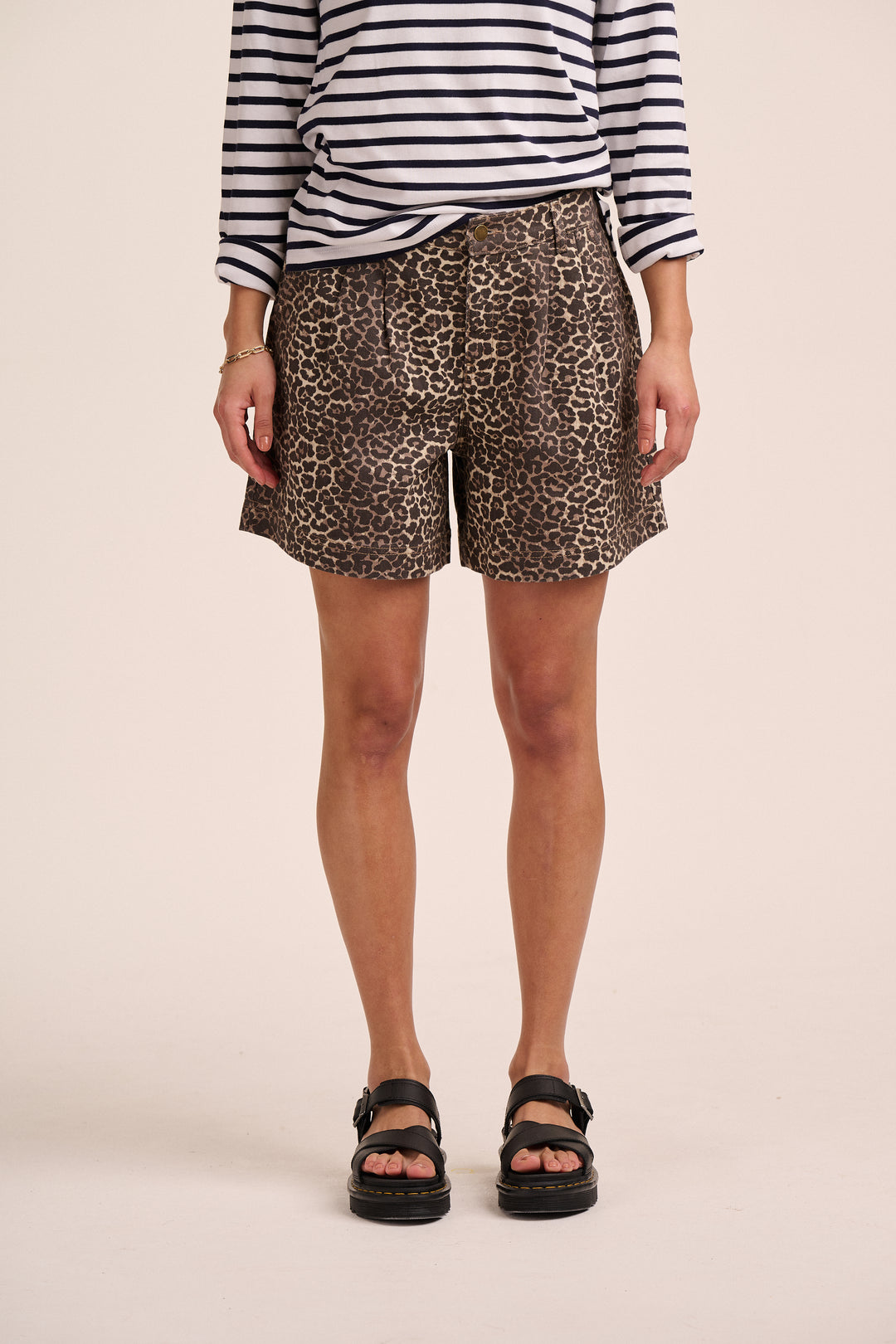 Model wearing leopard print pleated shorts with a navy breton striped top and black sandals